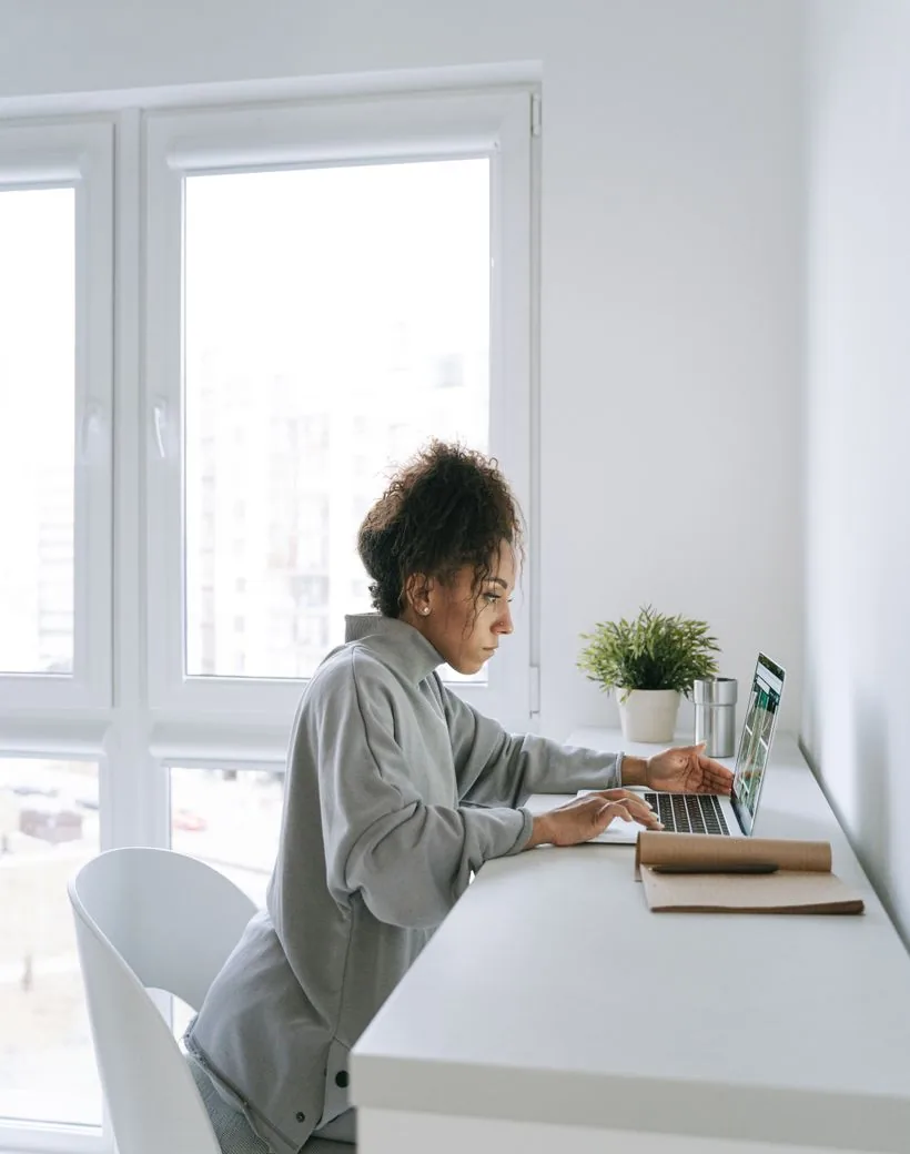 A Ledgerly bookkeeper working at a laptop in a bright modern workspace