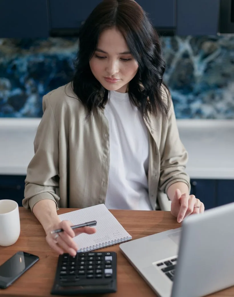 A Sterling Vance advisor reviewing figures with calculator and laptop