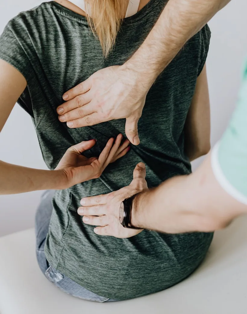Apex Motion — a chiropractor using hands-on care to assess an active patient's lower back during a session