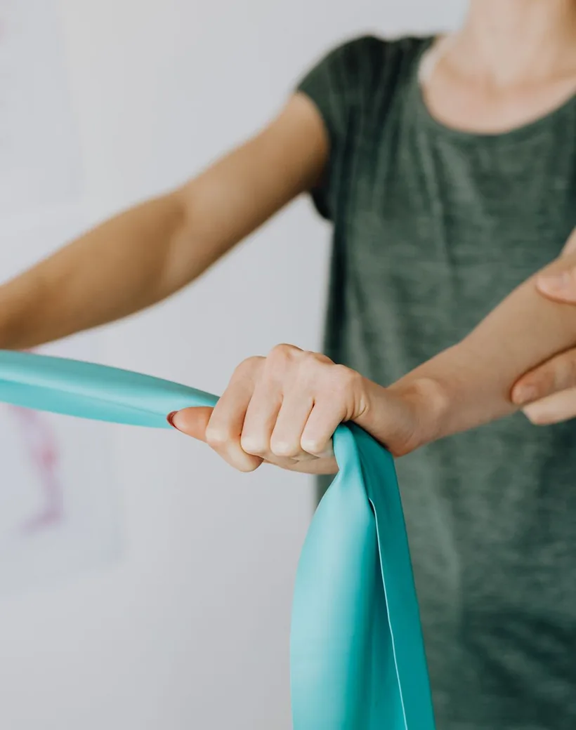 Meridian Spine Studio — a clinician guiding a patient through gentle, supportive movement with a resistance band