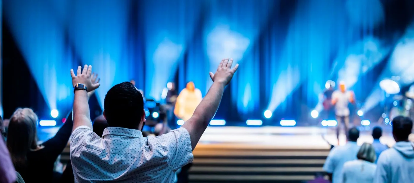 Elevation City Church — hands raised in worship under blue stage lights