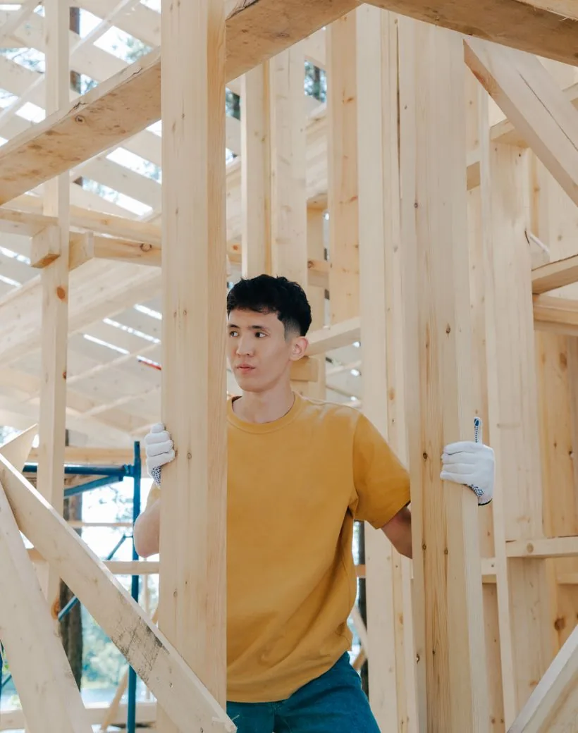 Alta North Custom Homes — a craftsman framing a new home by hand