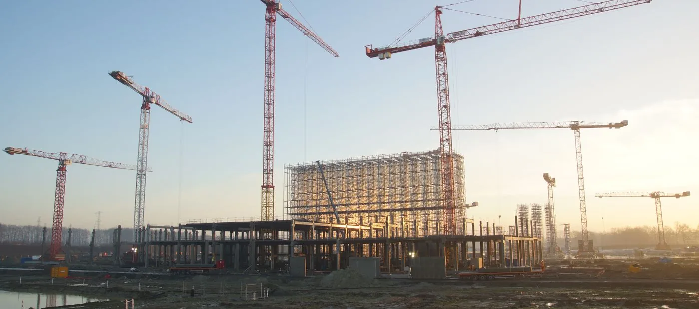 Bedrock Commercial — a large commercial building under construction with tower cranes at dusk