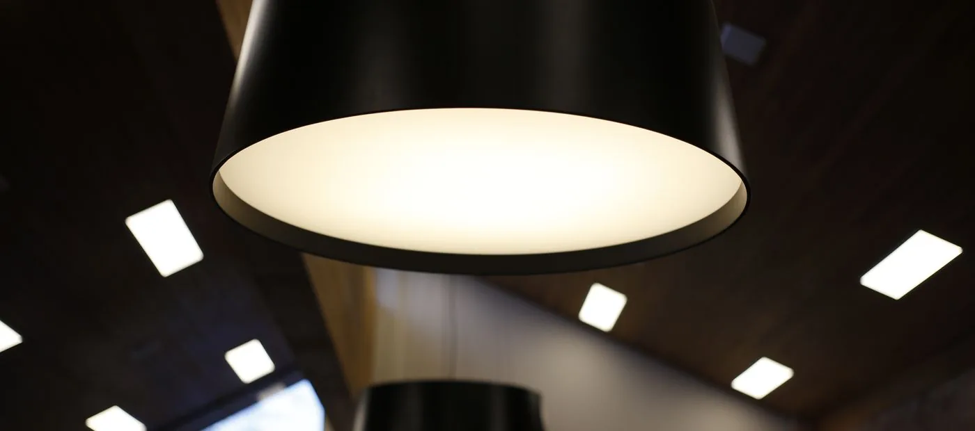 Lumen & Co. — architectural pendant lighting glowing in a dark modern interior