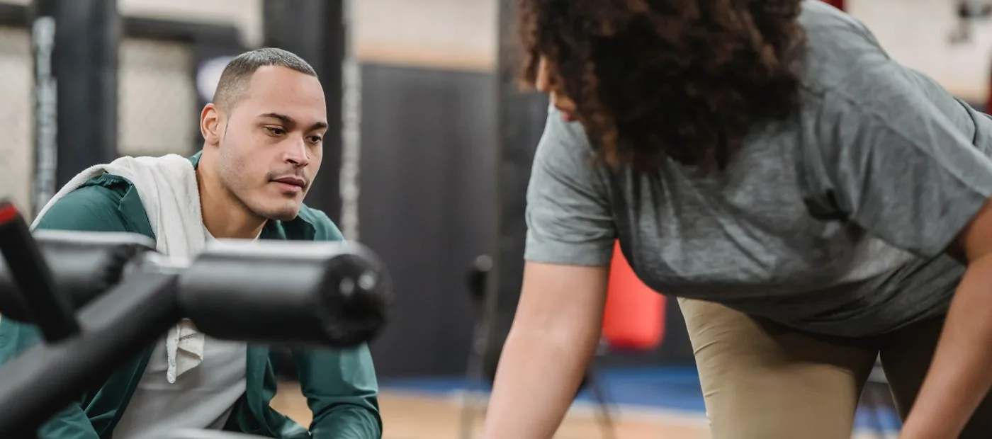 Personal trainer coaching a client through a session in a bright neighborhood gym