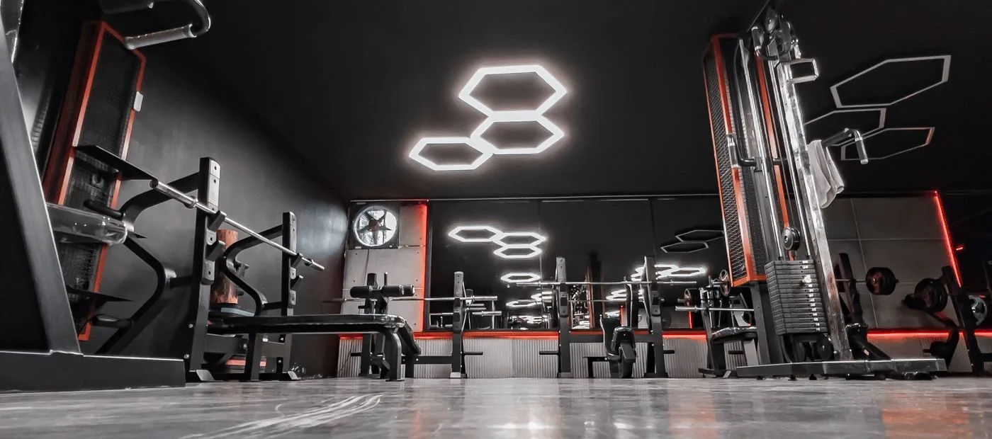 Cinematic boutique performance gym interior with moody lighting and premium equipment