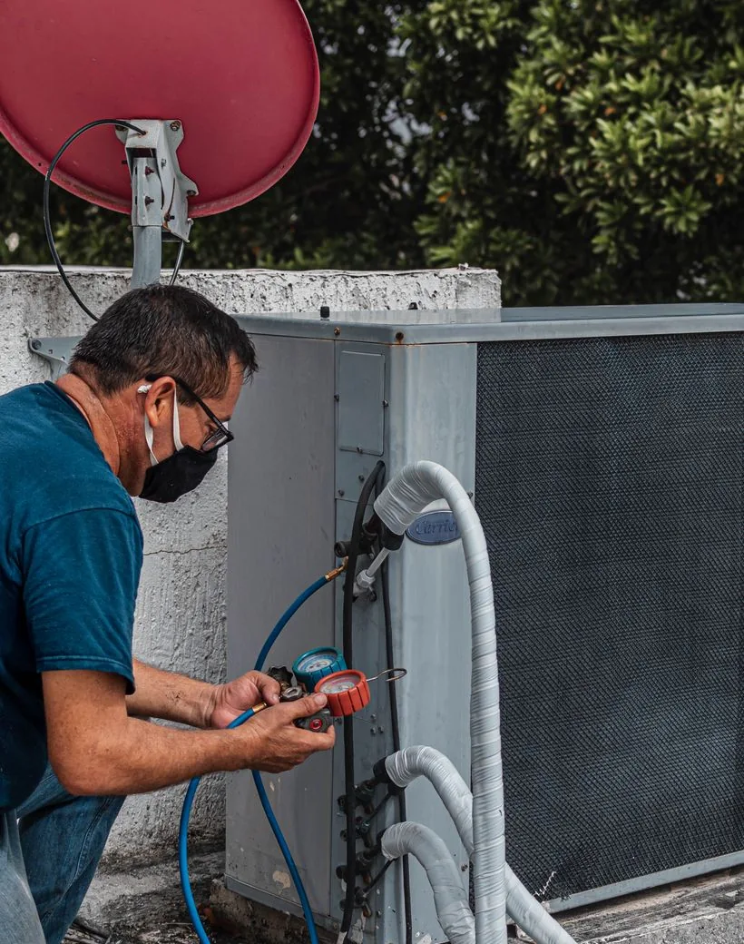 TrueNorth technician checking refrigerant on a residential AC condenser