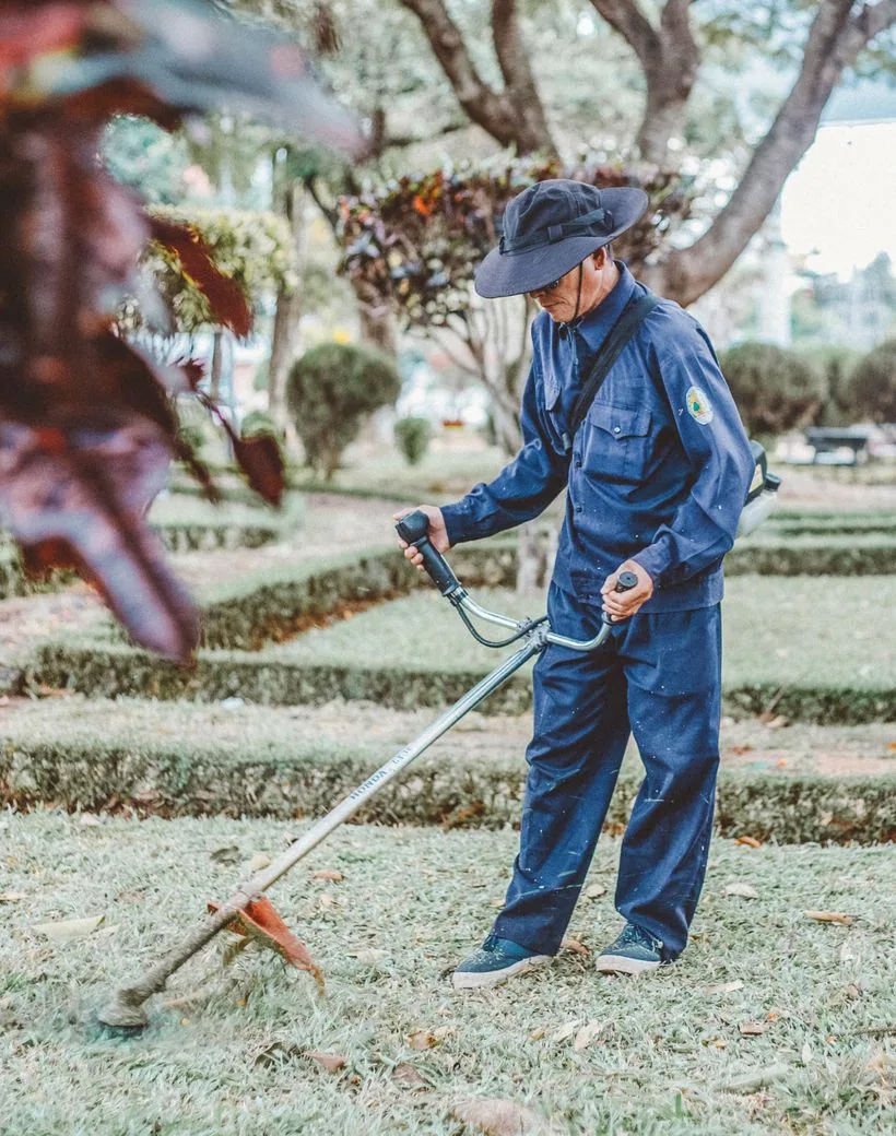 A Verdanta gardener tending and trimming a manicured formal garden