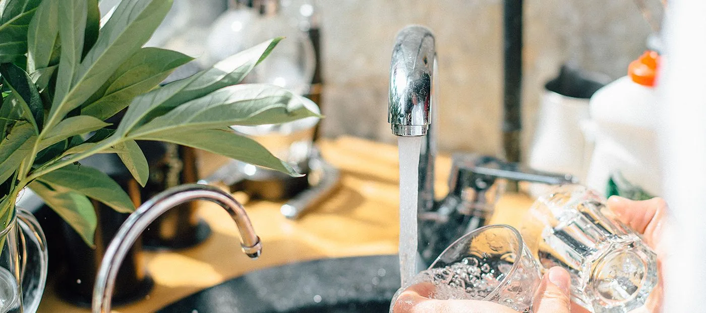 Rising Voices — tap water running into a glass at a neighbor's kitchen sink