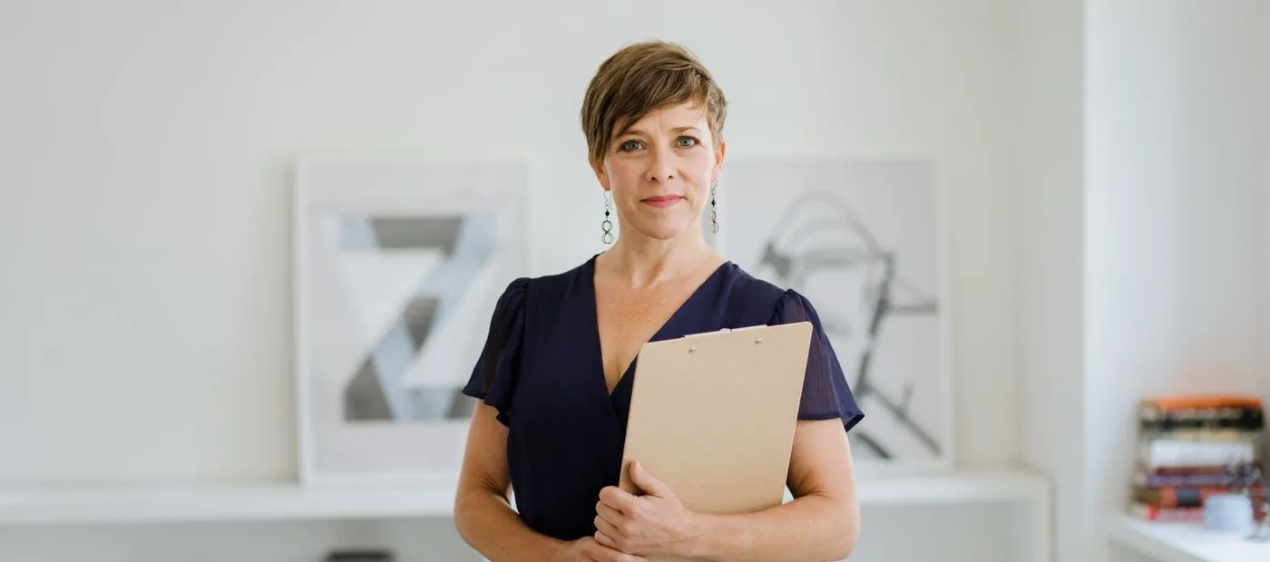 Confident creator holding a notebook in a bright, modern room