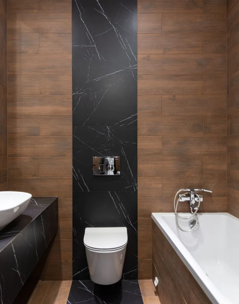 A finished bath remodel — warm wood, stone, and designer fixtures