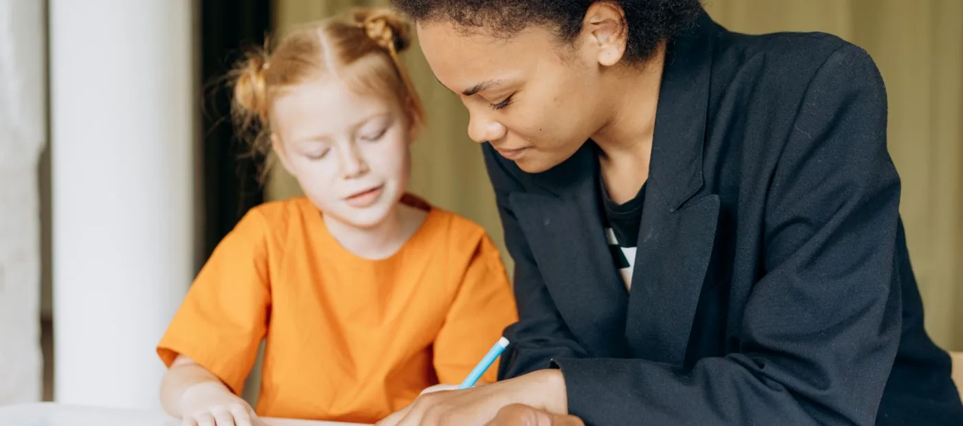 BrightPath Learning — a tutor sitting beside a young student, guiding her through her workbook