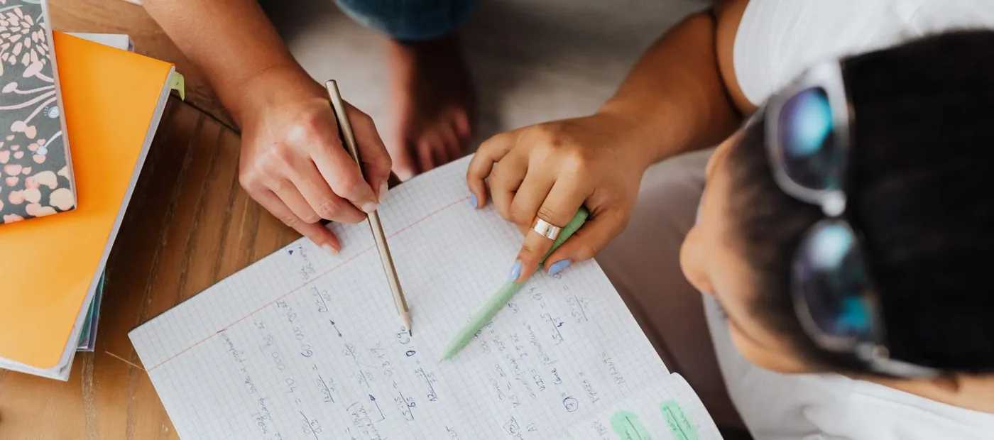 Summit Scores — a coach and student working through a practice problem step by step on paper