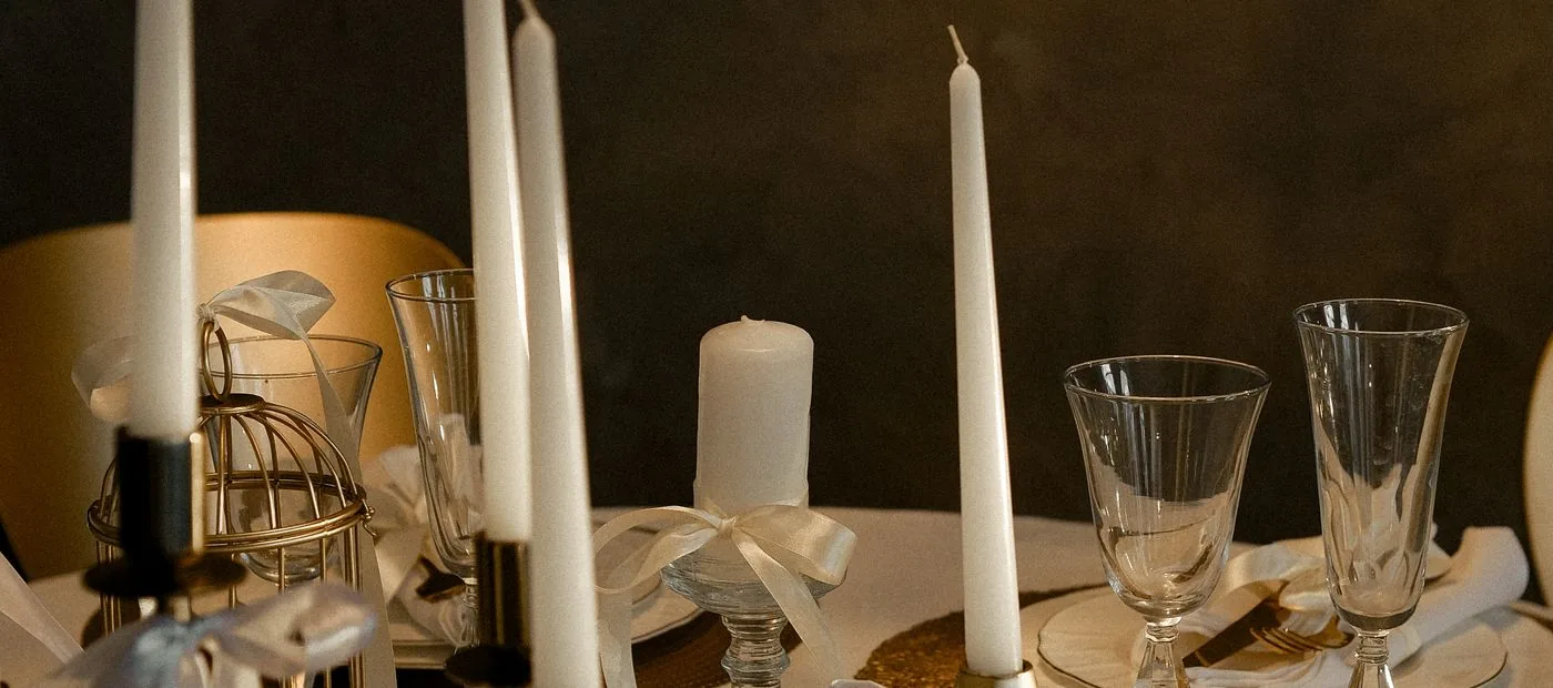 Maison Lumiere — a refined tablescape with gold candle holders, crystal, and ivory tapers