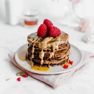 Fluffy pancakes stacked with berries and maple syrup